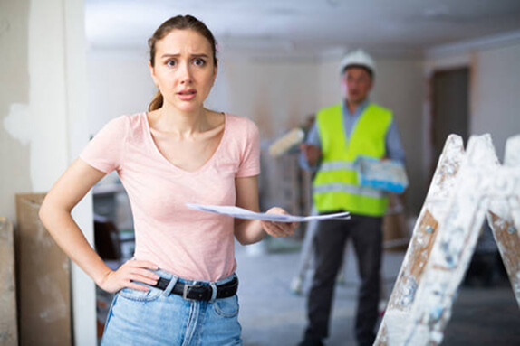 A homeowner looking concerned while reviewing a 2D floor plan